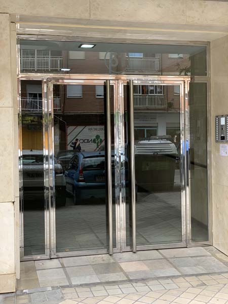 Portal de acceso comunitario en acero inoxidable y vidrio